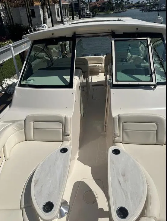 Slide: The Image of 2019 Grady-White Freedom 375 boat interior with seating and tables, docked by the water. - 37