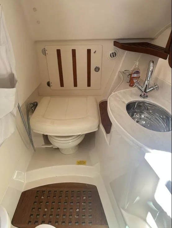 Slide: The Image of 2019 Grady-White Freedom 375 boat bathroom with toilet, sink, and wooden accents. - 40