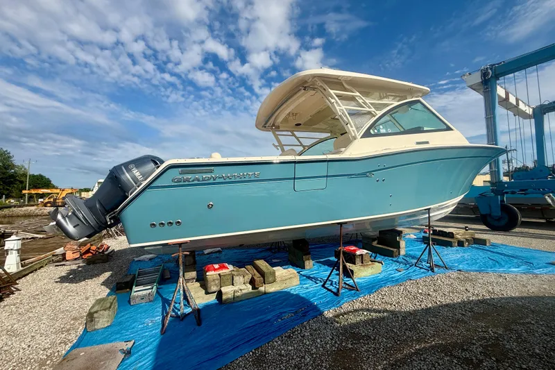 Slide: The Image of 2019 Grady-White Freedom 375 boat on stands, blue hull, clear sky background. - 6