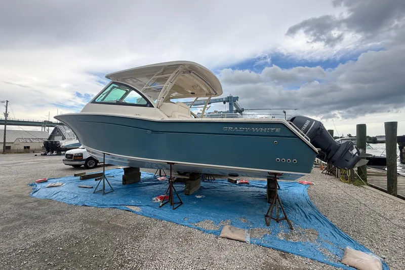 Slide: The Image of 2019 Grady-White Freedom 375 boat on stands, blue hull, overcast sky. - 9
