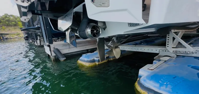 Slide: The Image of 2023 Malibu 25LSV boat on a dock, showcasing propeller and hull design. - 10