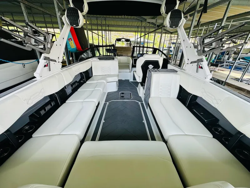 Slide: The Image of 2023 Malibu 25LSV boat interior with spacious white seating and modern design. - 13