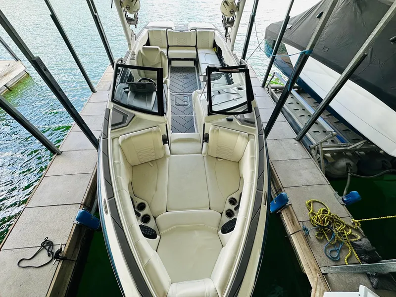 Slide: The Image of 2023 Malibu 25LSV boat docked, featuring spacious seating and sleek design. - 15