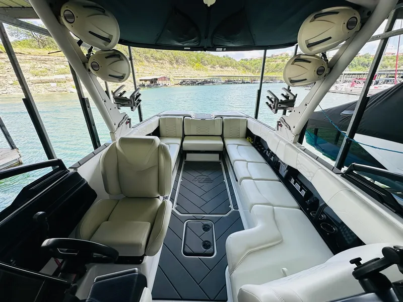 Slide: The Image of Interior of 2023 Malibu 25LSV boat with luxurious seating and speakers. - 16
