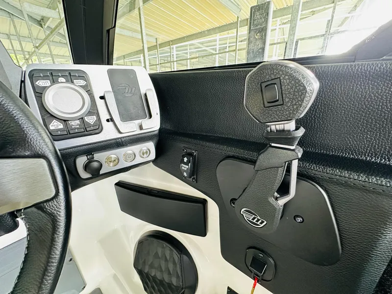 Slide: The Image of 2023 Malibu 25LSV boat dashboard with control panel and steering wheel. - 19