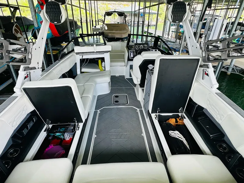 Slide: The Image of 2023 Malibu 25LSV boat interior with open storage compartments and seating. - 23