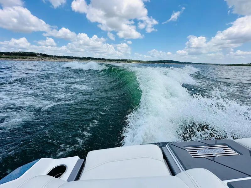 Slide: The Image of 2023 Malibu 25LSV creating waves on a sunny lake day. - 26