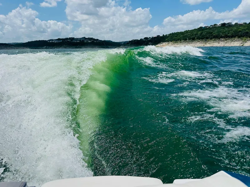 Slide: The Image of Waves created by a 2023 Malibu 25LSV boat on a sunny lake day. - 27