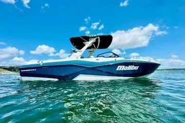 Slide: The Image of 2023 Malibu 25LSV boat on water under clear blue sky. - 28