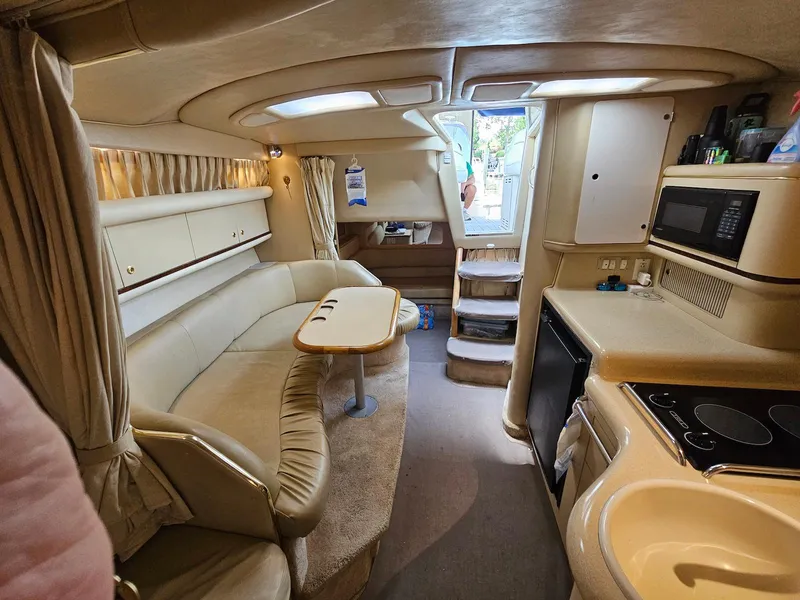 Slide: The Image of Interior of a 1998 Sea Ray 330 Sundancer yacht with beige seating and kitchenette. - 11
