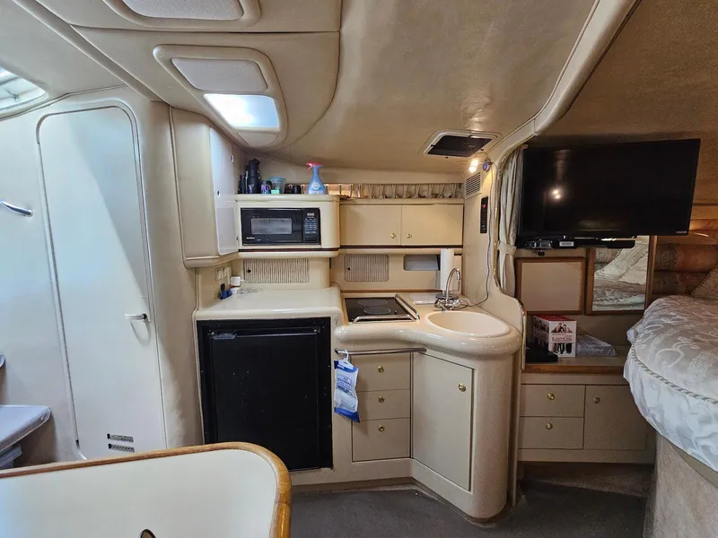 Slide: The Image of Interior of 1998 Sea Ray 330 Sundancer yacht with kitchenette and TV. - 14