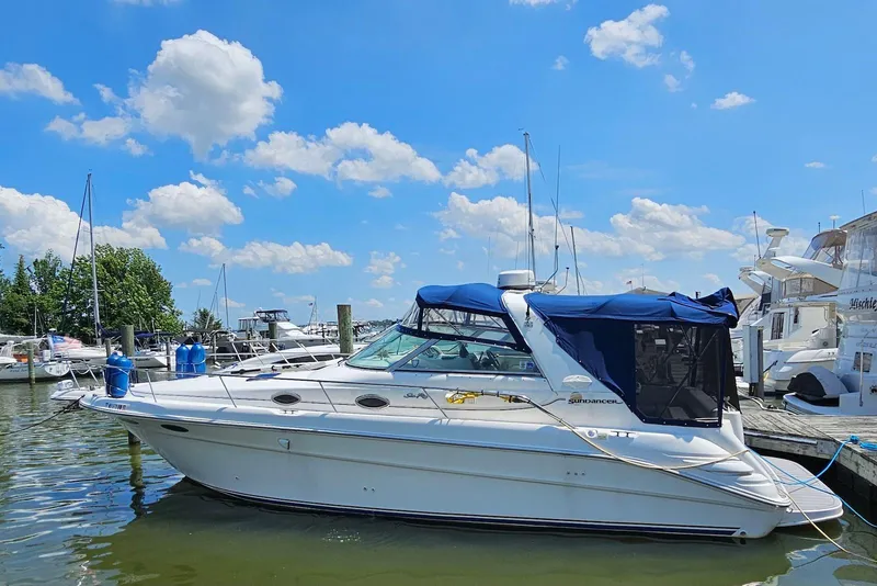 Slide: The Image of 1998 Sea Ray 330 Sundancer docked at marina under blue sky. - 3