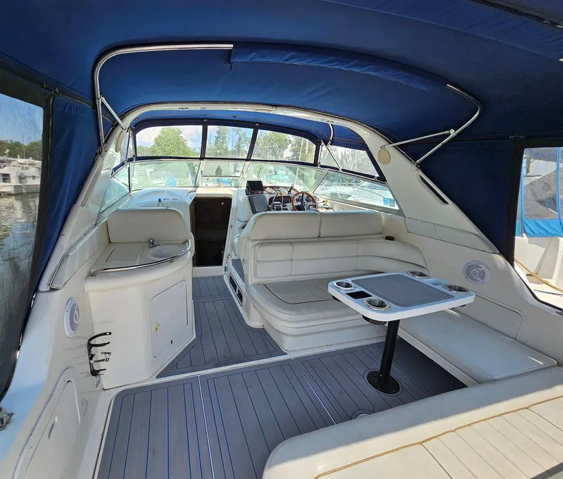 Slide: The Image of 1998 Sea Ray 330 Sundancer interior with blue canopy, white seating, and table. - 4