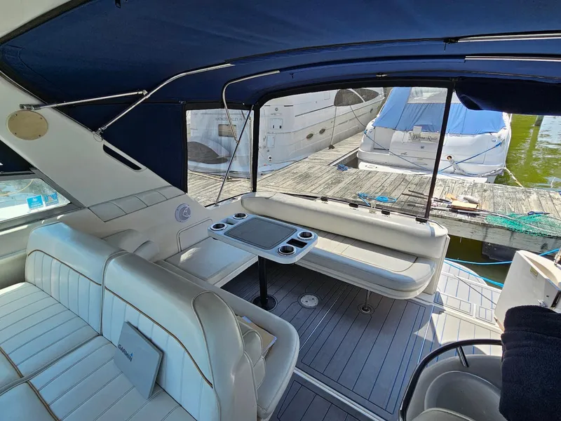Slide: The Image of 1998 Sea Ray 330 Sundancer interior with seating and table, docked at marina. - 5