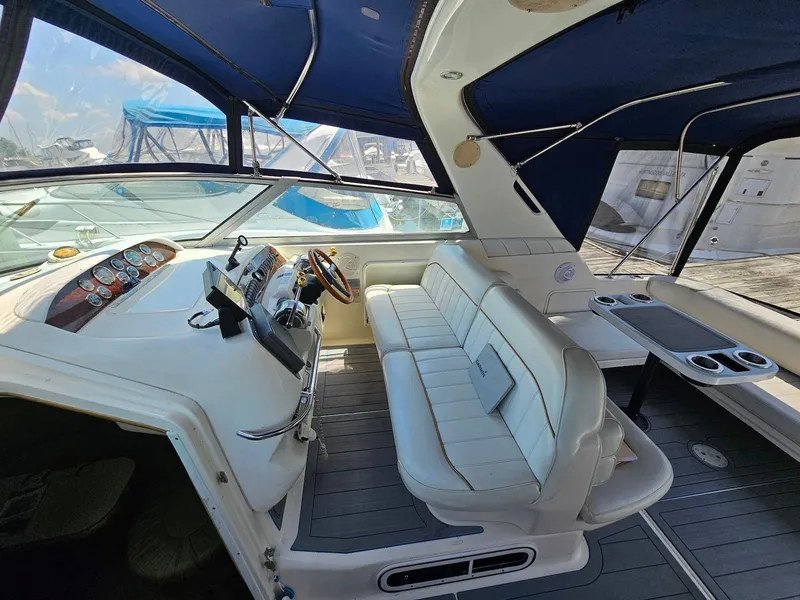 Slide: The Image of 1998 Sea Ray 330 Sundancer cockpit with white seating and blue canopy. - 6