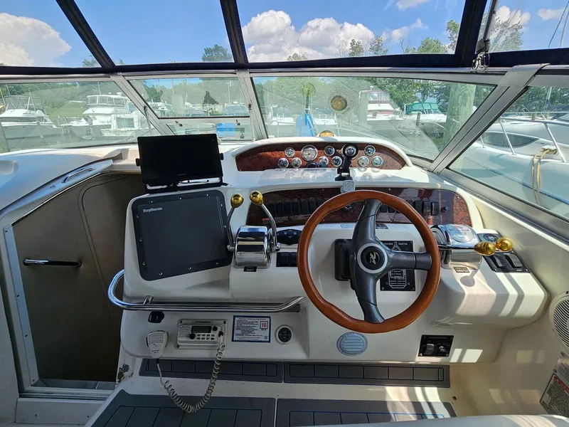 Slide: The Image of 1998 Sea Ray 330 Sundancer helm with steering wheel, gauges, and navigation equipment. - 7