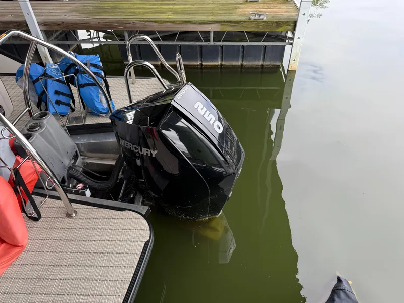 Slide: The Image of 2019 Barletta L23UC boat with Mercury outboard motor docked by the water. - 3