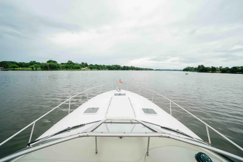Slide: The Image of Bow view of 2000 Sea Ray 340 Sundancer cruising on a calm lake. - 11