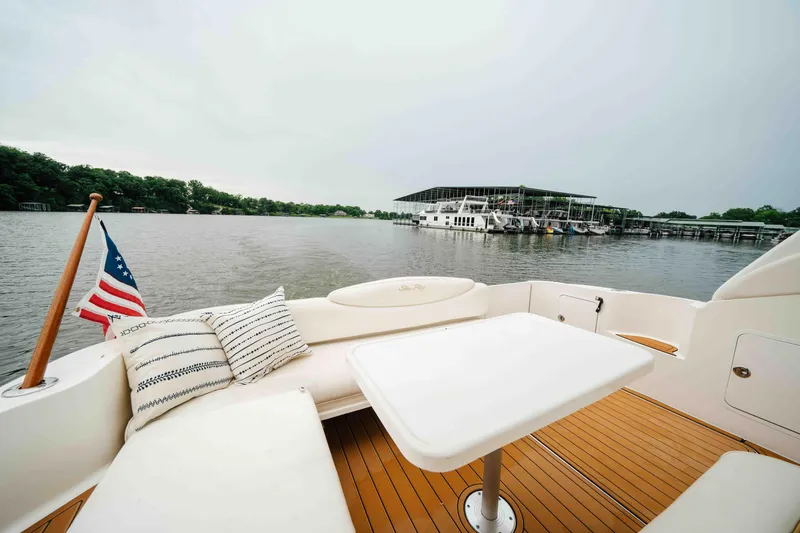 Slide: The Image of Cozy seating area on a 2000 Sea Ray 340 Sundancer yacht, overlooking a serene marina. - 15
