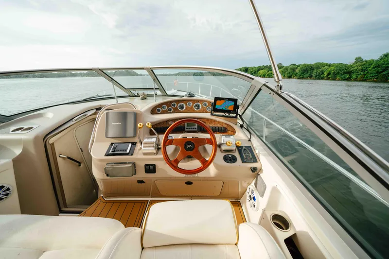 Slide: The Image of 2000 Sea Ray 340 Sundancer helm with wood steering wheel, on a calm lake. - 17