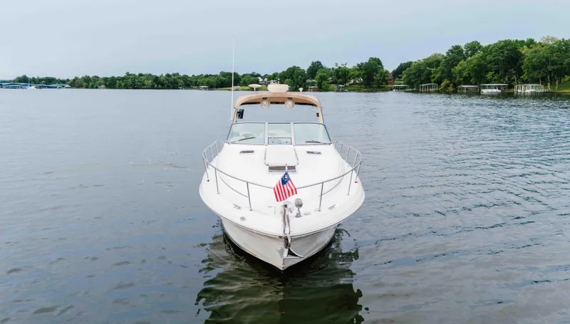 Slide: The Image of 2000 Sea Ray 340 Sundancer yacht on a calm lake with trees in the background. - 2