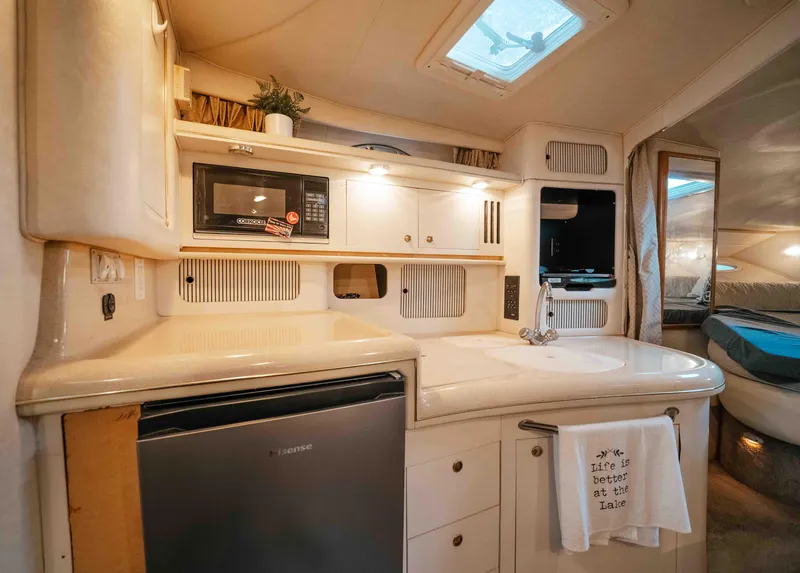 Slide: The Image of Interior of 2000 Sea Ray 340 Sundancer yacht with kitchenette and cozy sleeping area. - 31