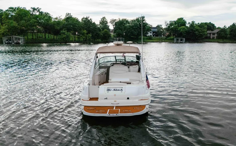 Slide: The Image of 2000 Sea Ray 340 Sundancer boat on a calm lake with lush green shoreline. - 7