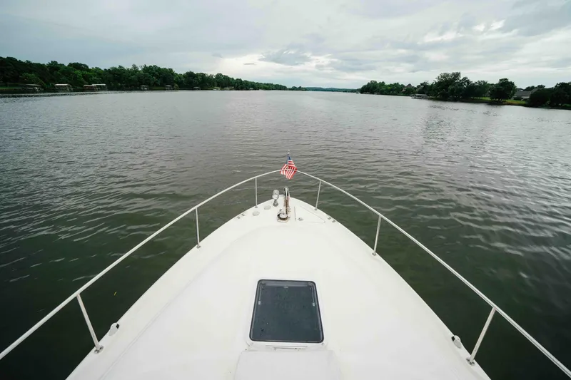 Slide: The Image of Bow view of 2000 Sea Ray 340 Sundancer on a calm lake with cloudy skies. - 8