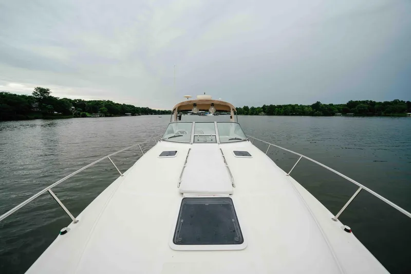 Slide: The Image of 2000 Sea Ray 340 Sundancer cruising on a calm lake under overcast skies. - 9