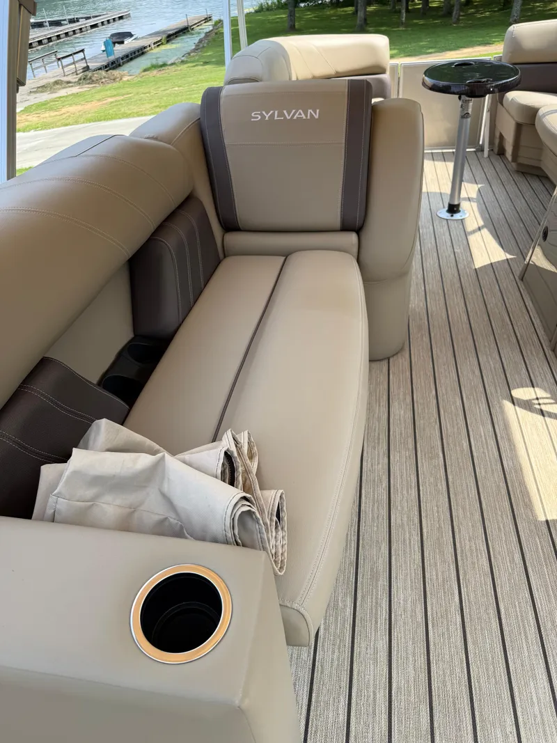 Slide: The Image of 2021 Sylvan Mirage 822 PARTY FISH boat interior with beige seating and cup holder. - 4