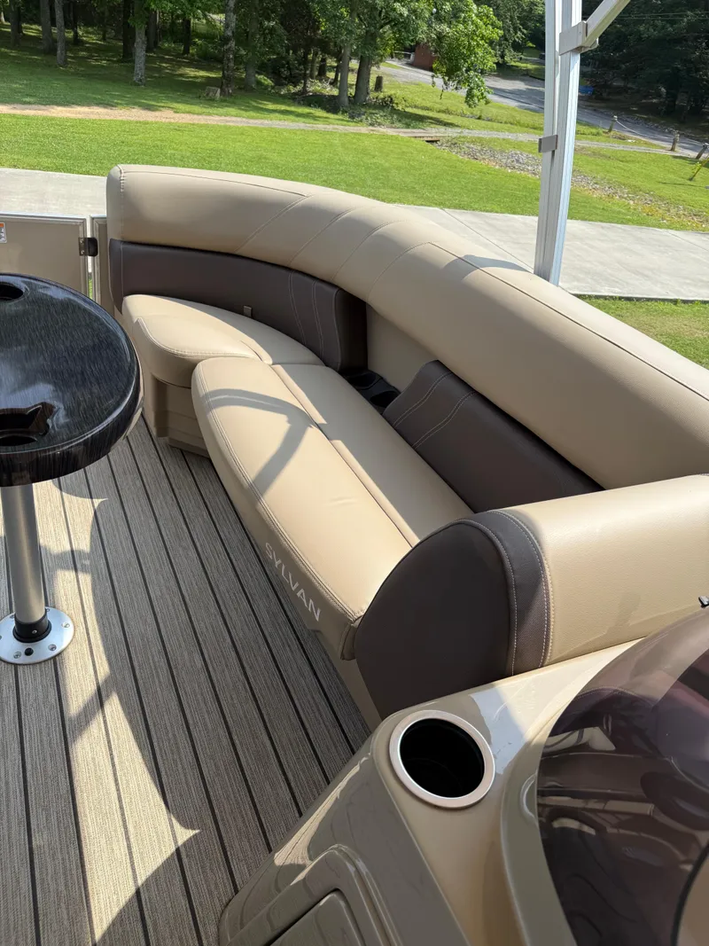 Slide: The Image of 2021 Sylvan Mirage 822 PARTY FISH boat interior with beige seating and table. - 5