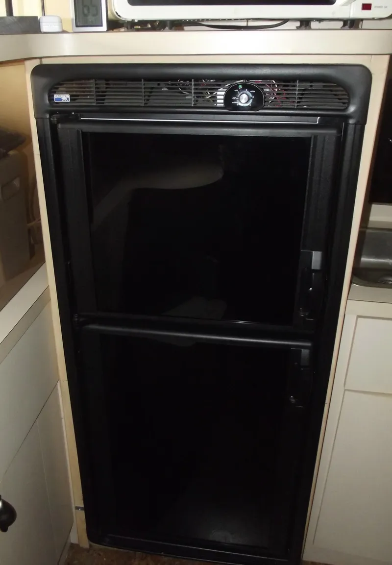 Slide: The Image of Black refrigerator inside a 1990 Silverton 37 Convertible boat kitchen area. - 15