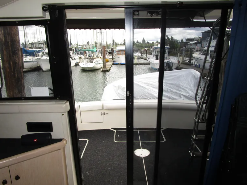 Slide: The Image of 1990 Silverton 37 Convertible yacht interior view with marina backdrop. - 23