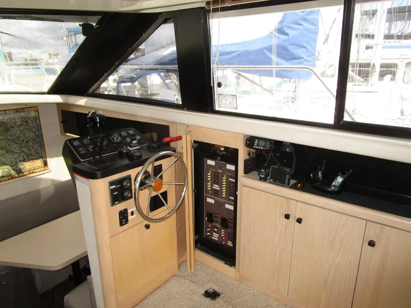 Slide: The Image of 1990 Silverton 37 Convertible yacht helm with steering wheel and control panel. - 26