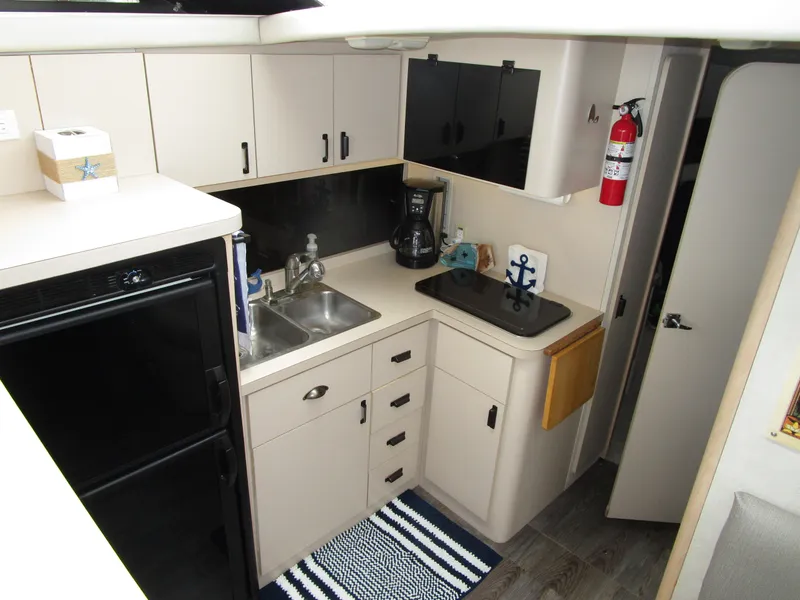 Slide: The Image of 1990 Silverton 37 Convertible yacht kitchen with sink, stove, and cabinets. - 28