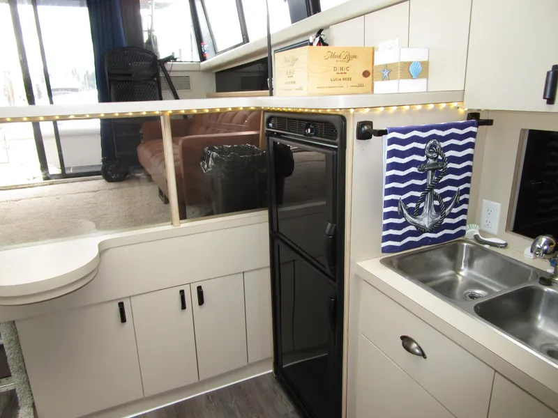 Slide: The Image of Interior of 1990 Silverton 37 Convertible yacht with kitchenette and nautical decor. - 29