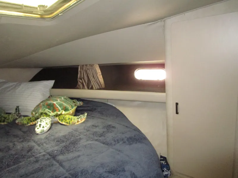 Slide: The Image of Cozy cabin interior of 1990 Silverton 37 Convertible with plush bedding and stuffed turtle. - 34