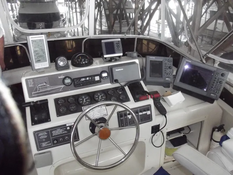 Slide: The Image of 1990 Silverton 37 Convertible boat cockpit with navigation instruments and steering wheel. - 4