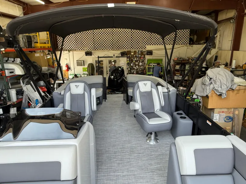 Slide: The Image of 2025 Viaggio Lago V-U pontoon boat interior with gray seating and canopy in a workshop. - 16