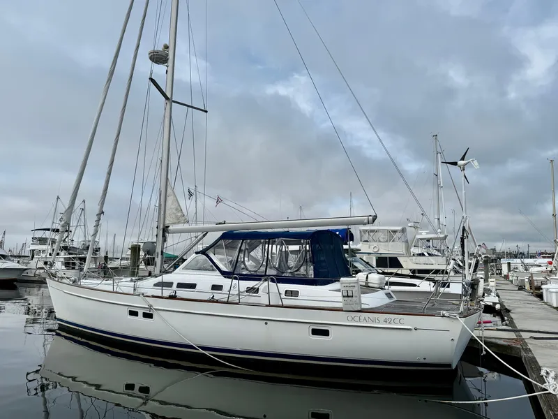 Slide: The Image of 2003 Beneteau Oceanis 42CC sailboat docked at marina under cloudy sky. - 2