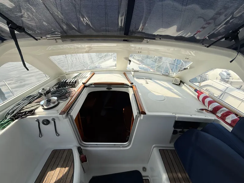 Slide: The Image of 2003 Beneteau Oceanis 42CC cockpit with ropes, winch, and open hatch under canopy. - 22