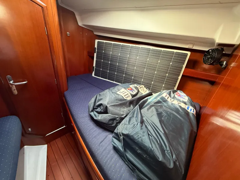 Slide: The Image of Interior of 2003 Beneteau Oceanis 42CC with solar panel and bags on bed. - 26
