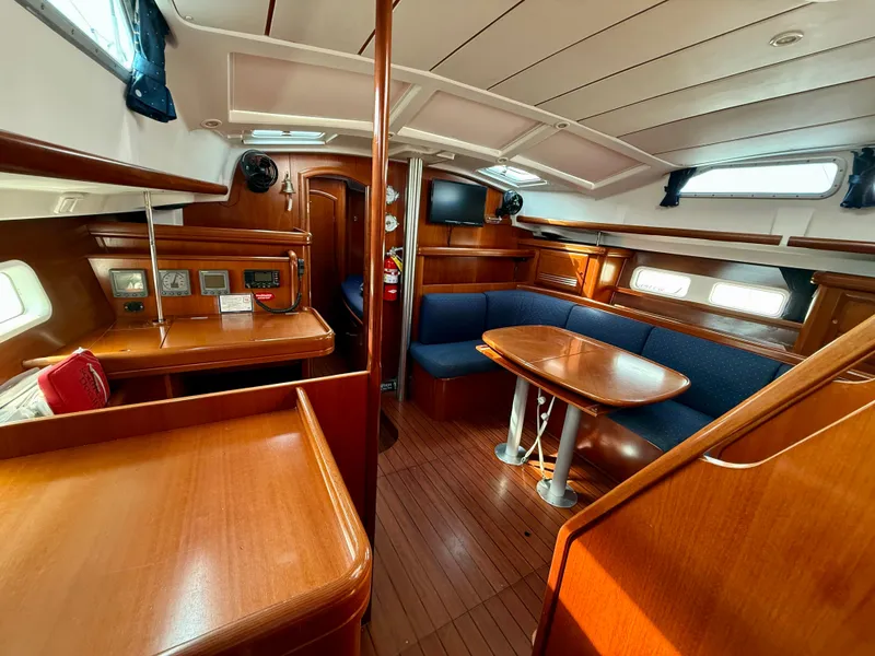 Slide: The Image of Interior of 2003 Beneteau Oceanis 42CC sailboat with wooden furnishings and blue seating. - 30