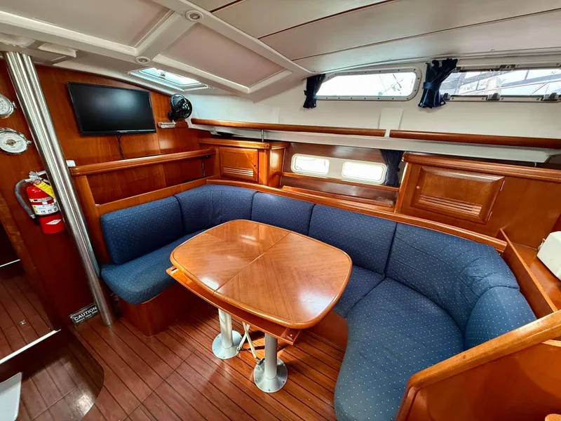 Slide: The Image of Interior of 2003 Beneteau Oceanis 42CC yacht with cozy seating and wooden table. - 31