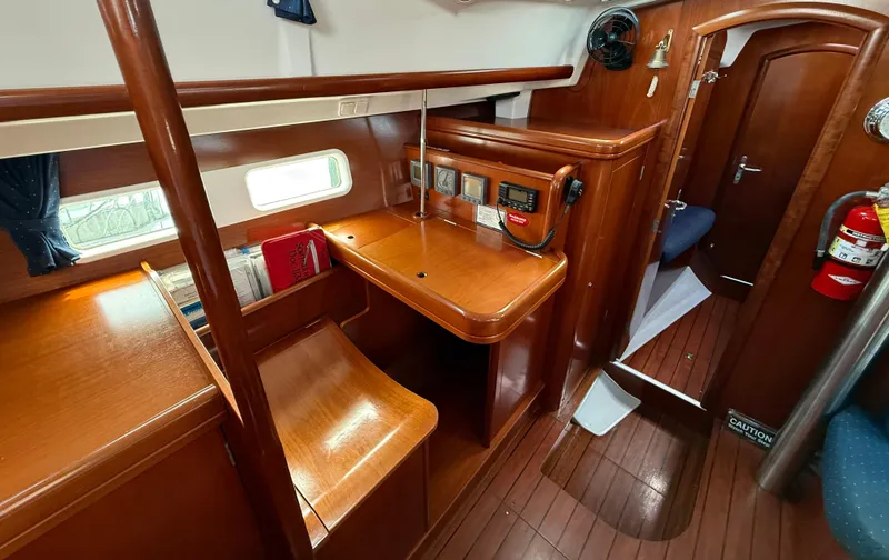 Slide: The Image of Interior of 2003 Beneteau Oceanis 42CC sailboat with wooden furnishings and navigation station. - 32