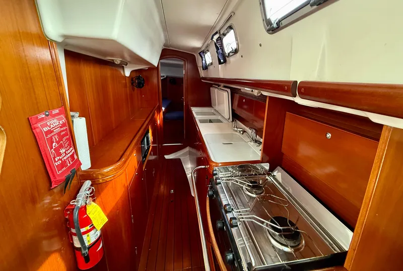 Slide: The Image of Interior of 2003 Beneteau Oceanis 42CC yacht, featuring a compact galley with stove and sink. - 35