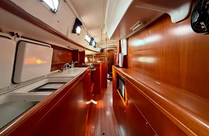 Slide: The Image of Interior of 2003 Beneteau Oceanis 42CC yacht, featuring sleek wood cabinetry and modern amenities. - 36