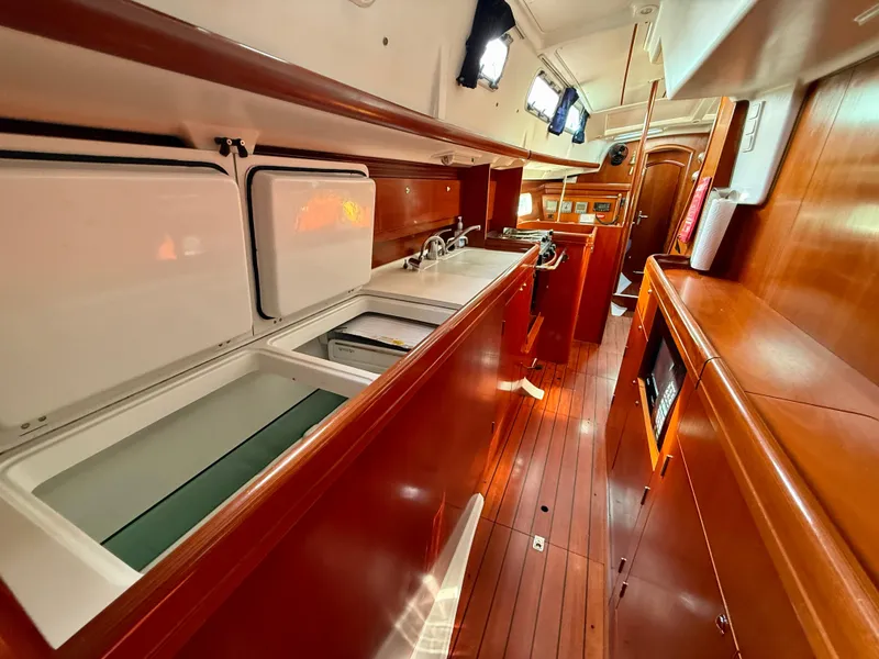 Slide: The Image of Interior of 2003 Beneteau Oceanis 42CC yacht, featuring a sleek wooden galley design. - 37