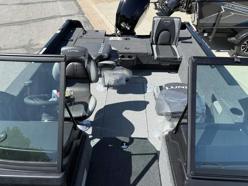Slide: The Image of 2025 Lund 1775 Impact XS boat interior with seating and windshield, showcasing modern design. - 2