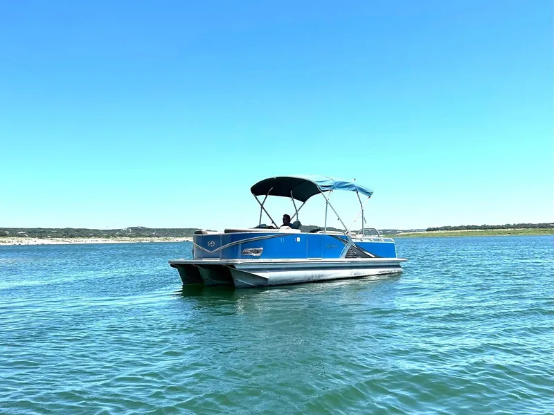 Slide: The Image of 2022 Avalon 24 LSZ VRB-3 pontoon boat cruising on a sunny lake. - 13